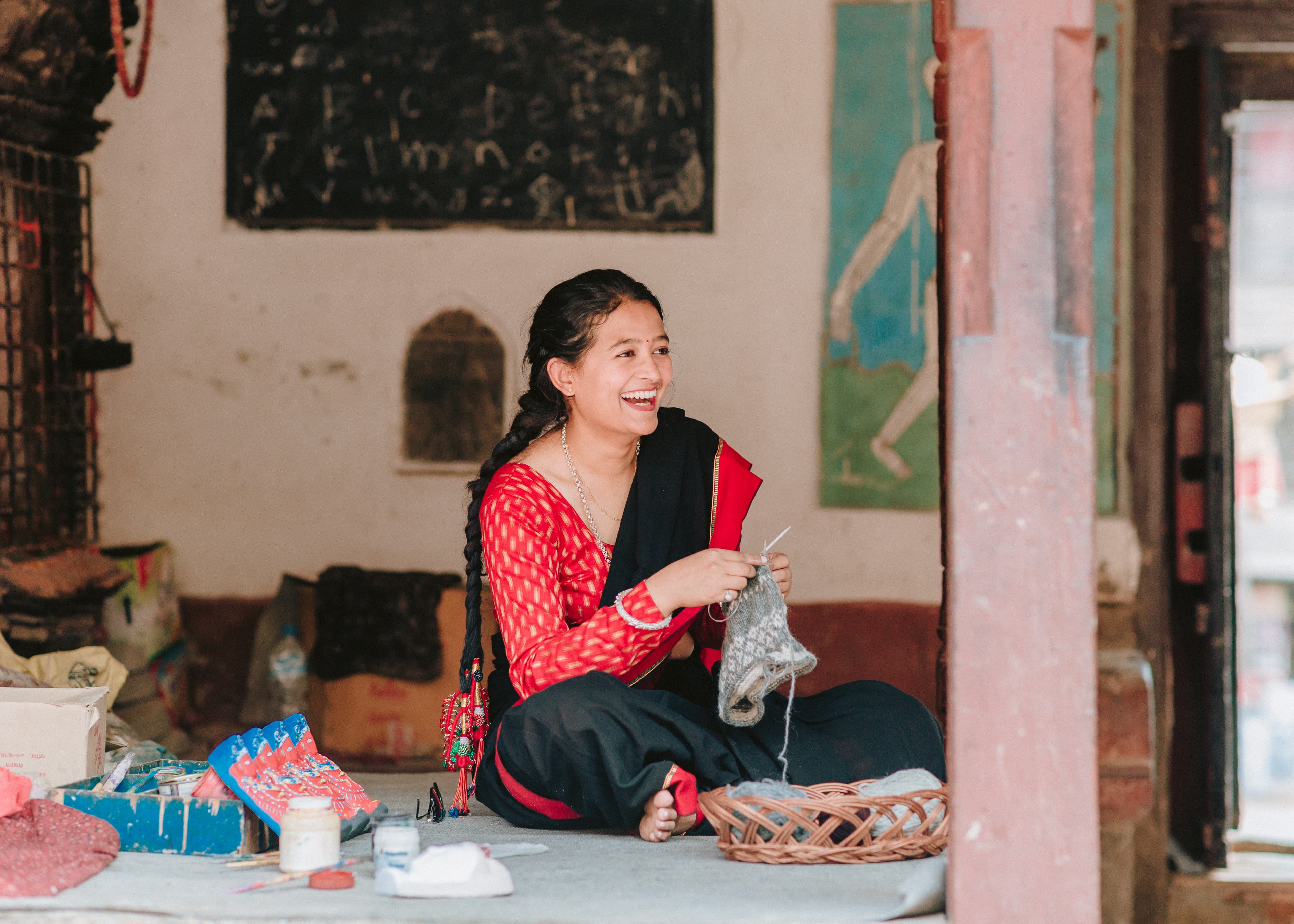 Elderly Nepalese artisan spinning wool on a traditional wooden wheel